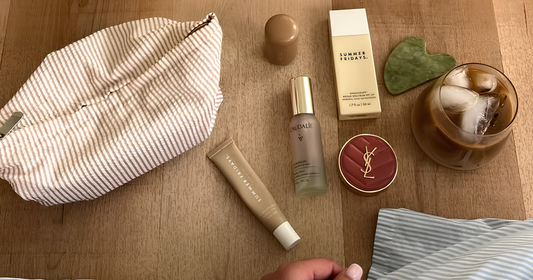 Cosmetic products and a glass of iced coffee on a wooden surface