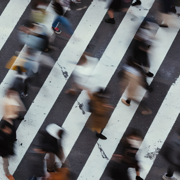 Blurred image of people crossing a crosswalk.
