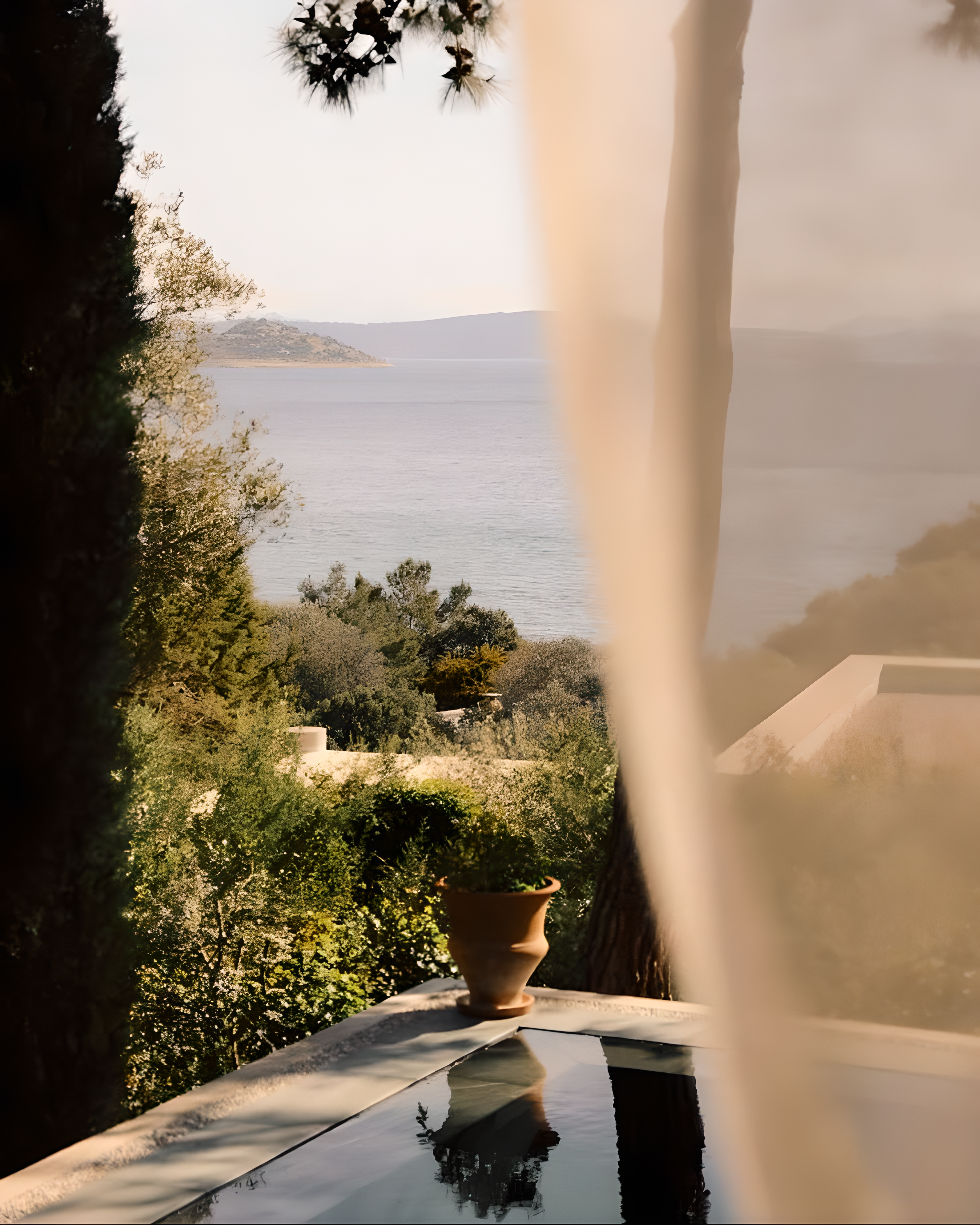 View of a scenic landscape with trees and water, framed by architectural elements.